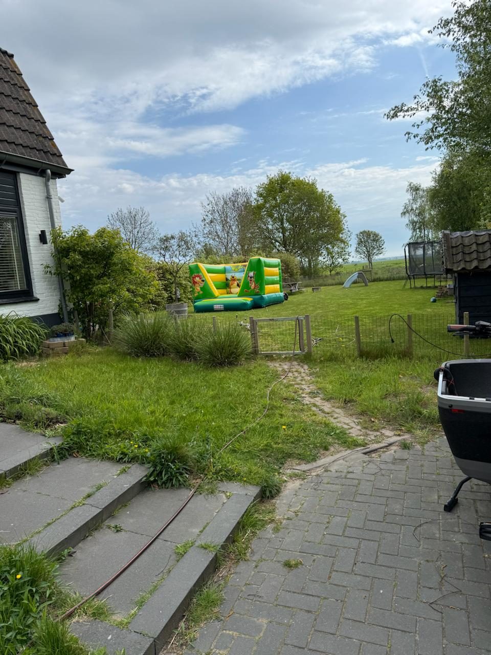 Groen geel springkussen opgezet in een ruime tuin